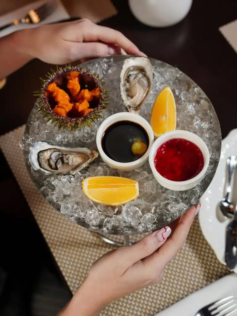 Plateau de fruits de mer sur glace pilée, huîtres fraîches, oursin, citron et sauces, restaurant ARIA Paris