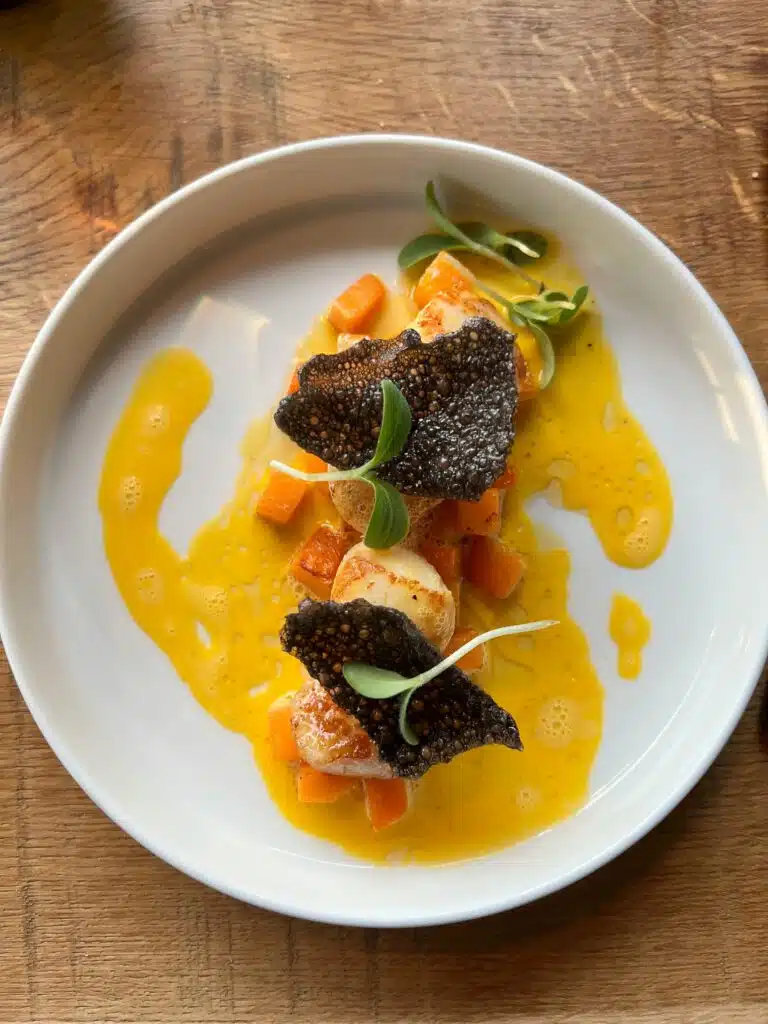 Noix de Saint-Jacques poêlées aux lamelles de truffe noire, sauce safranée et dés de carottes, restaurant ARIA Paris