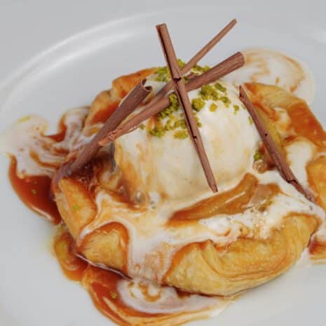 Le Caramel — Tarte feuilletée pommes et glace vanille, ARIA Paris Tarte feuilletée aux pommes caramélisées, glace vanille, sauce caramel et copeaux de chocolat, restaurant ARIA Paris