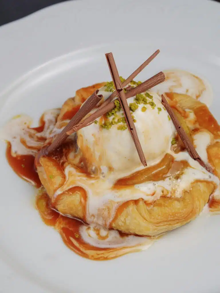 Tarte feuilletée aux pommes caramélisées, glace vanille, sauce caramel et copeaux de chocolat, restaurant ARIA Paris