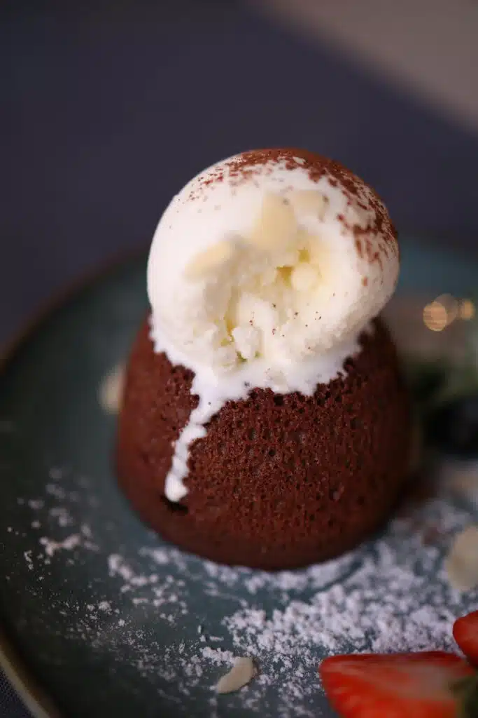 Moelleux au chocolat, boule de glace vanille fondante, sucre glace et fraise fraîche, restaurant ARIA Paris