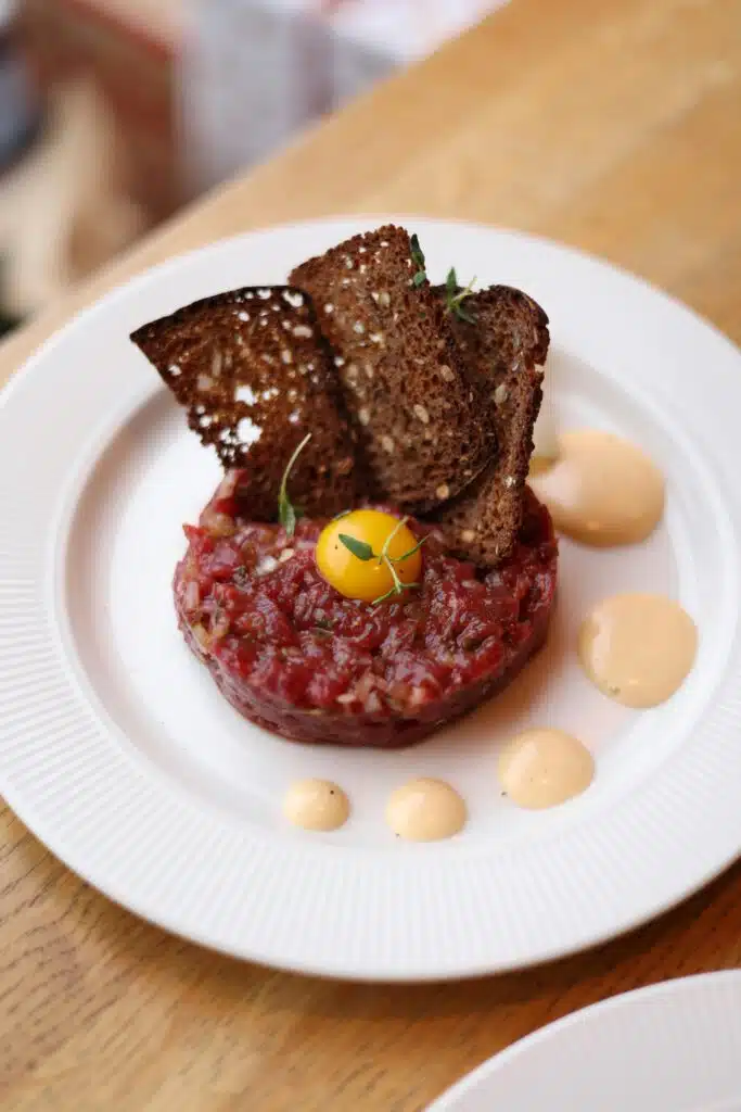 Tartare de bœuf façonné, jaune d'œuf de caille, toasts de pain noir et sauce moutardée, restaurant ARIA Paris
