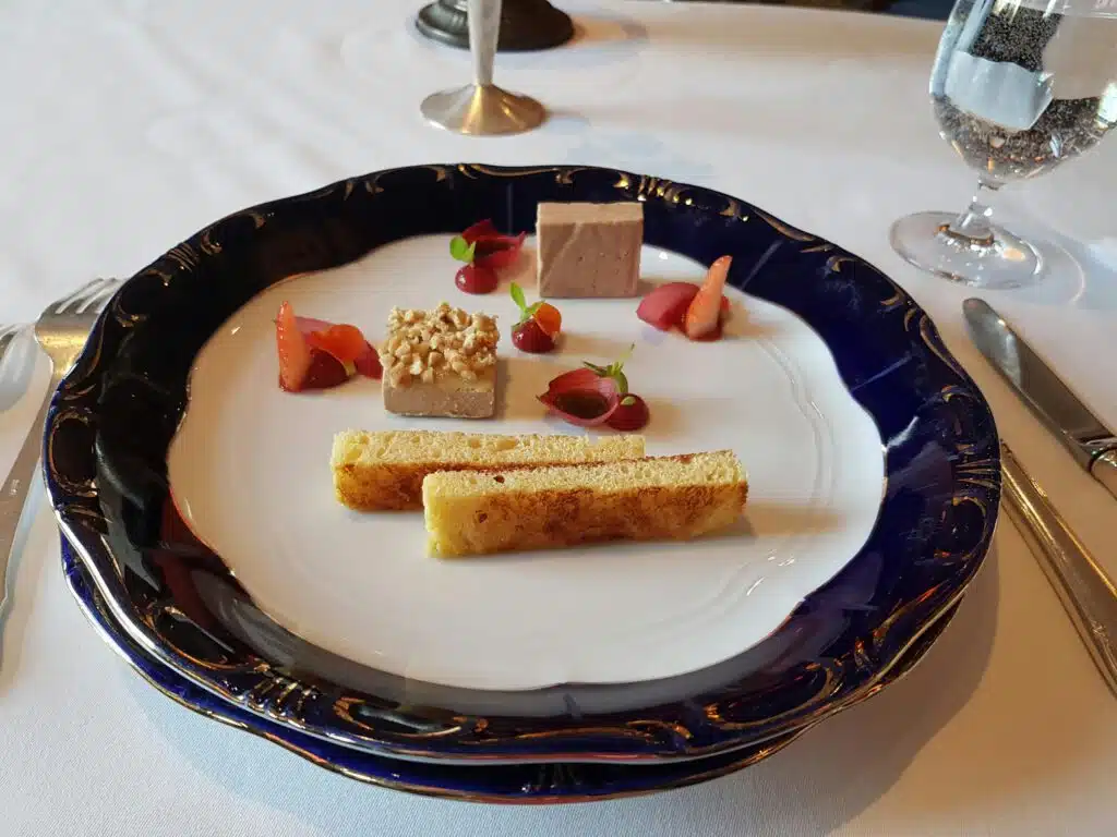 Foie gras en deux textures, fraises fraîches, condiments et toasts briochés sur assiette bleue cobalt, restaurant ARIA Paris