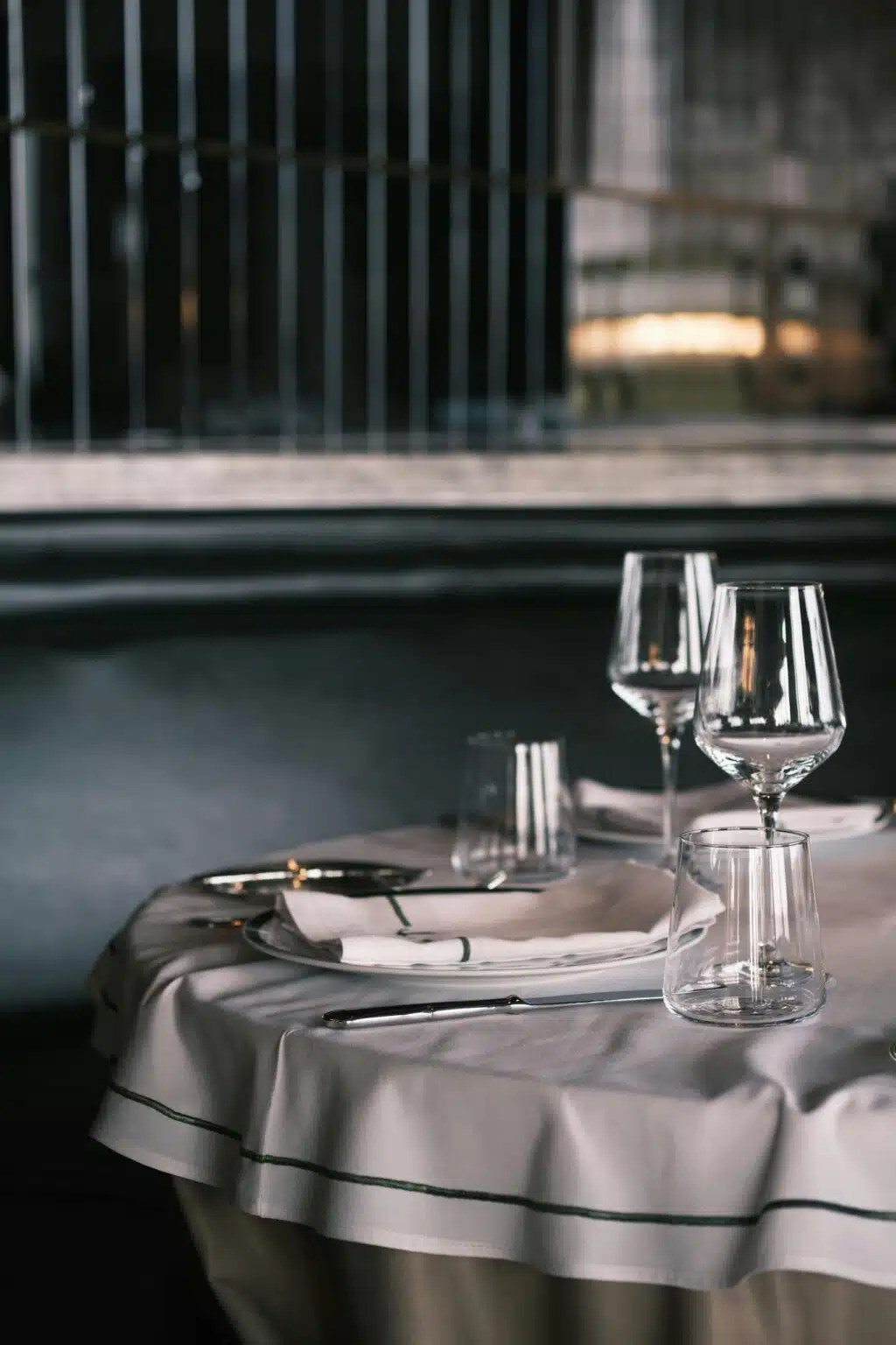 Table dressée avec soin au restaurant gastronomique ARIA à Paris, nappe blanche et verres à vin dans une ambiance intimiste